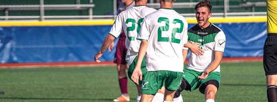 Members of the FLCC men's soccer team gathering on the field during a match.