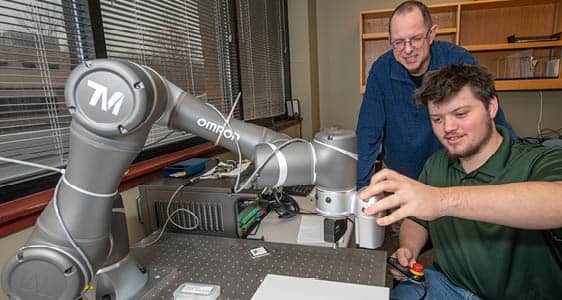 An FLCC student and faculty member work on a project using advanced manufacturing technology.